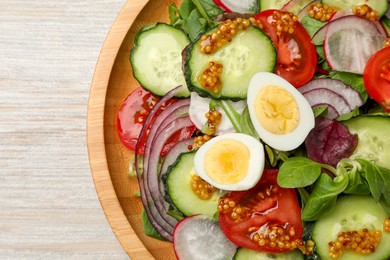 Photo of Tasty salad with vegetables and quail eggs on wooden table, top view