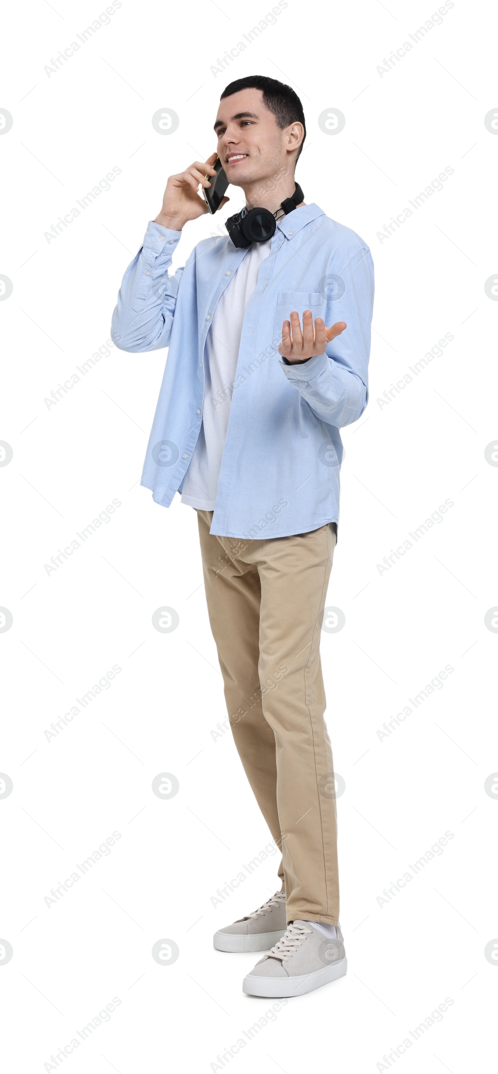 Photo of Young man with headphones talking on mobile phone on white background