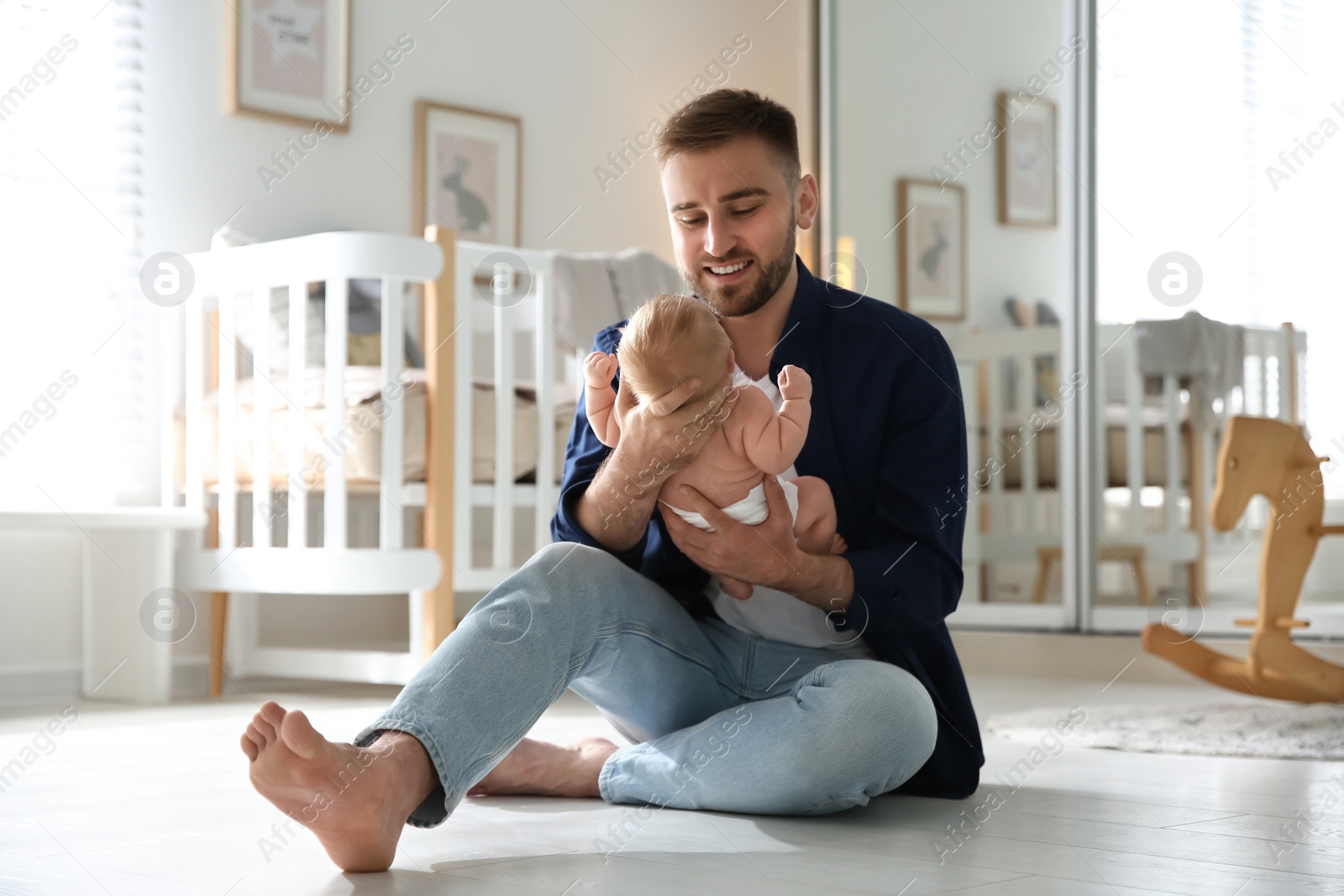 Photo of Father with his newborn son at home