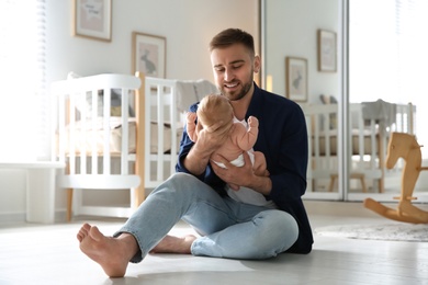 Photo of Father with his newborn son at home