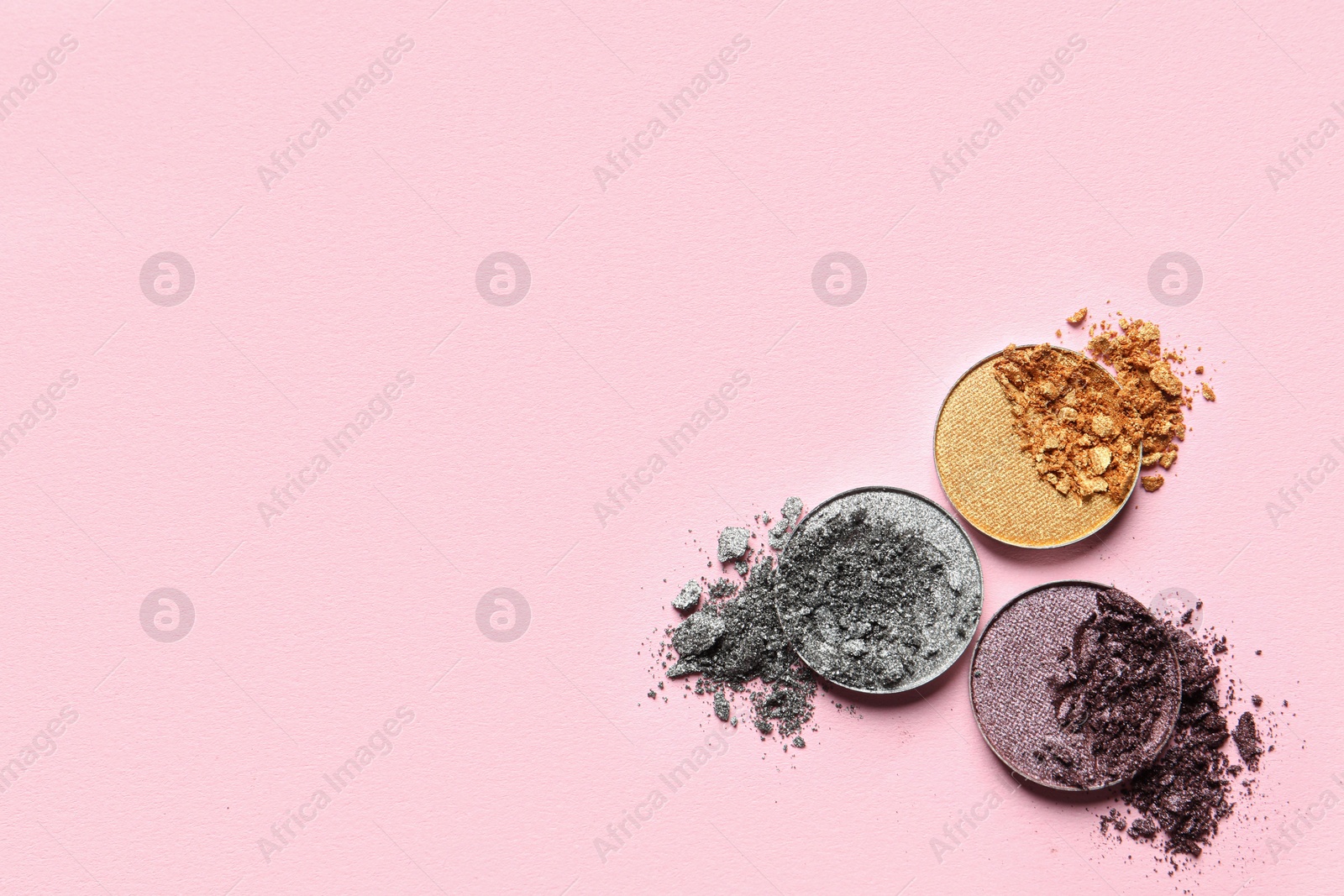 Photo of Different crushed eye shadows on pink background, flat lay. Space for text