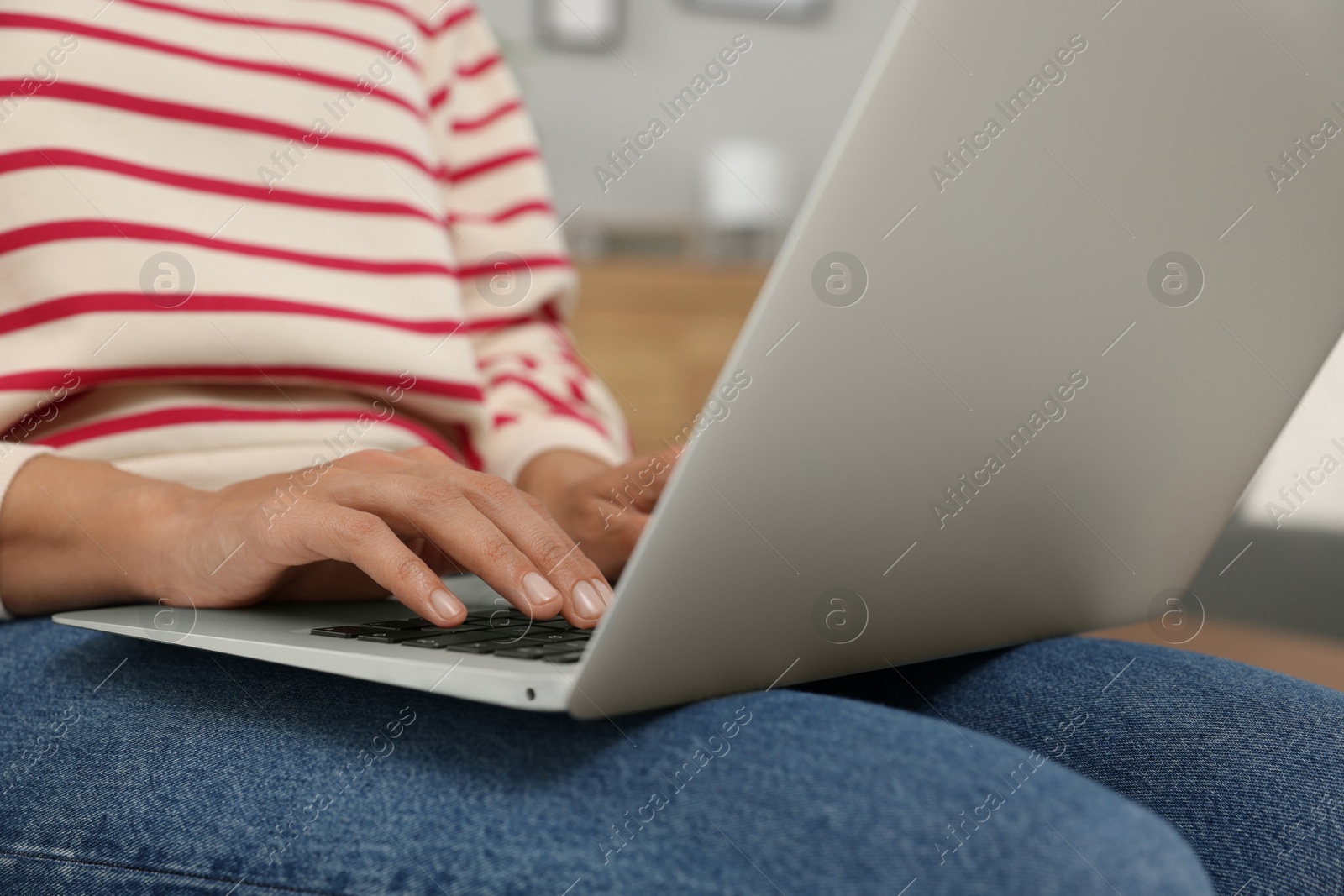 Photo of Woman using laptop in room, closeup view