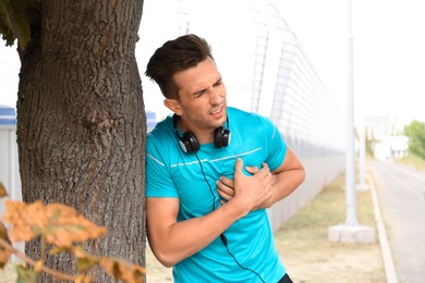 Young man having heart attack while running outdoors