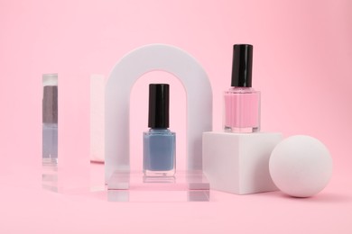 Photo of Stylish presentation of nail polishes on pink background