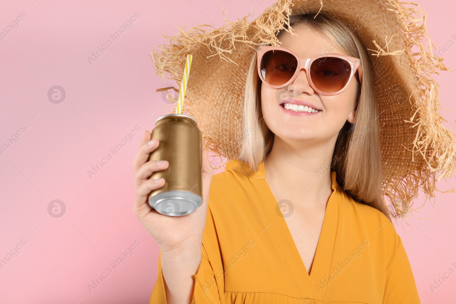 Photo of Beautiful happy woman holding beverage can on pink background