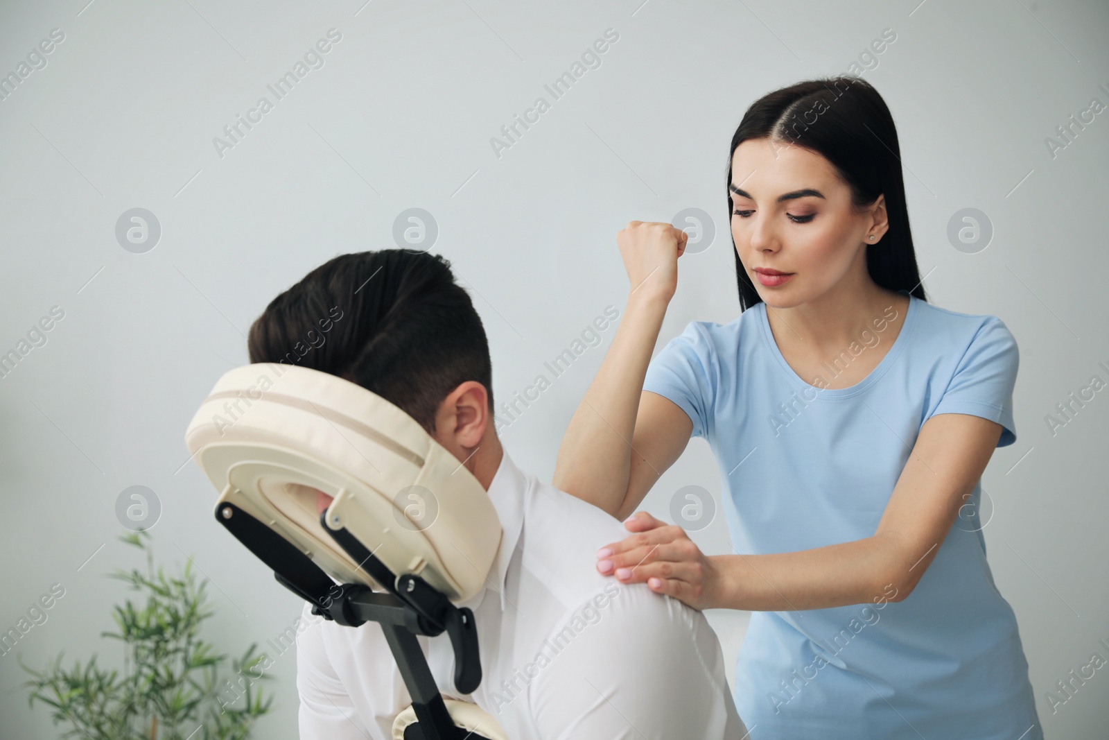 Photo of Man receiving massage in modern chair indoors