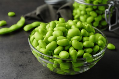 Photo of Bowl of delicious edamame beans on grey table, closeup