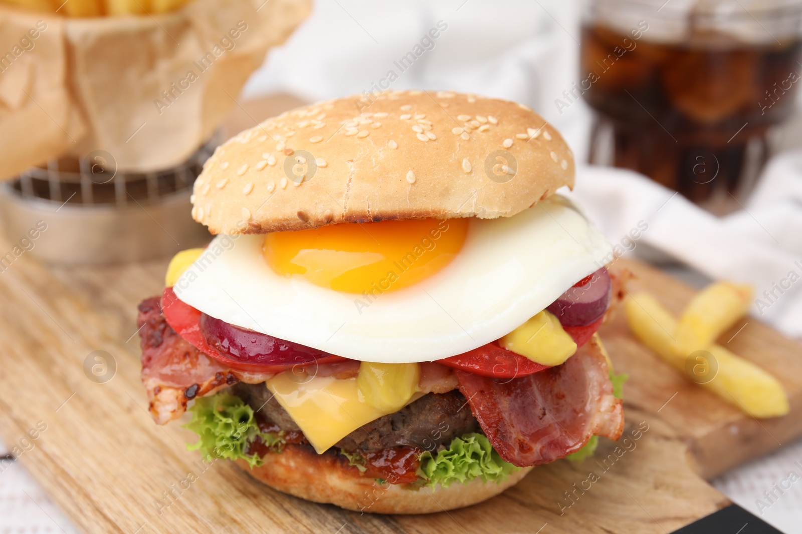 Photo of Delicious burger with fried egg on table, closeup