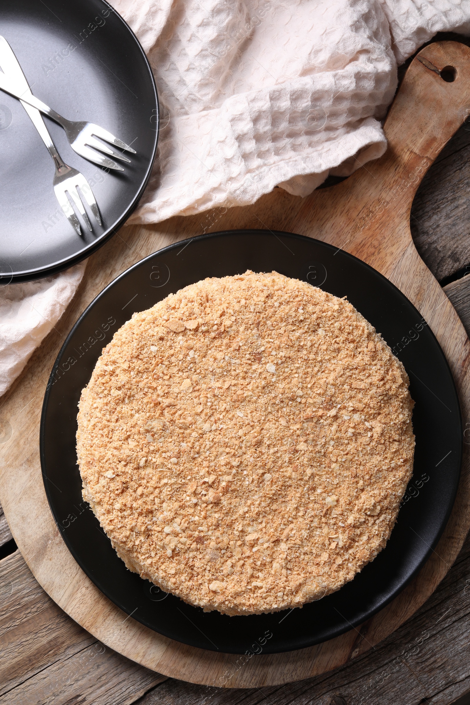 Photo of Delicious Napoleon cake on wooden table, top view