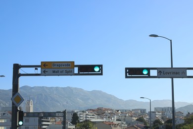 Photo of View of traffic lights with road signs in city under blue sky