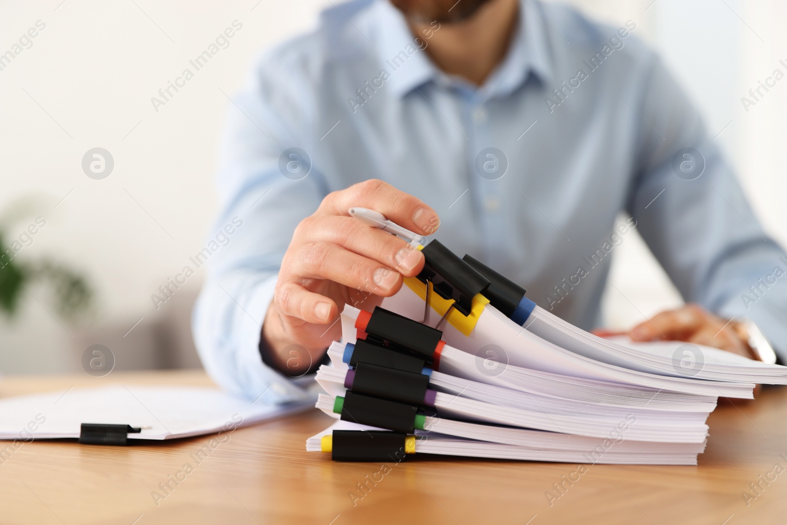 Photo of Businessman with documents at wooden table in office, closeup