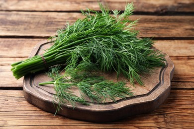Photo of Bunch of fresh dill on wooden table