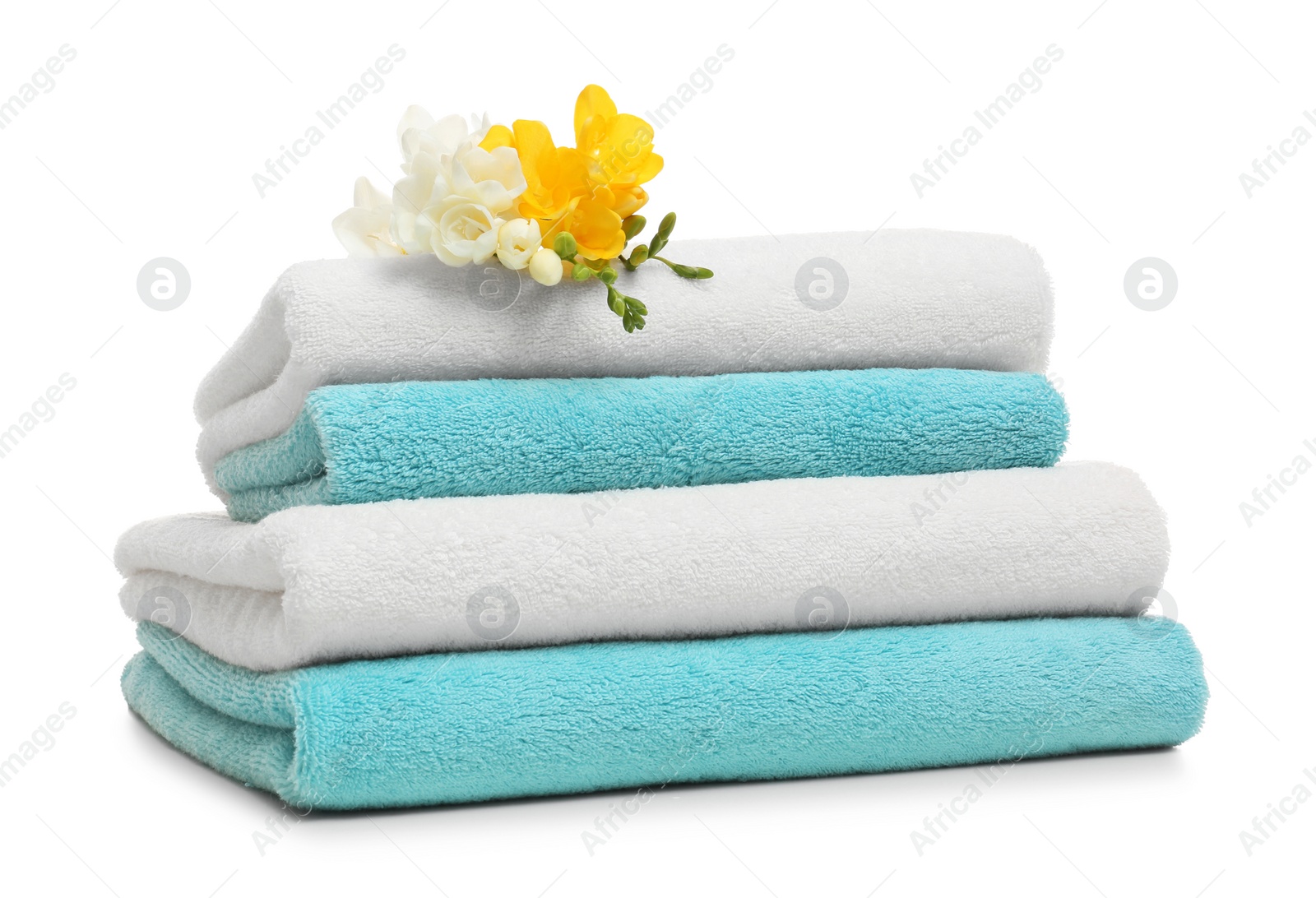 Photo of Stack of clean folded towels with flowers on white background