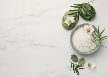 Flat lay composition with spa products and flowers on white marble table. Space for text