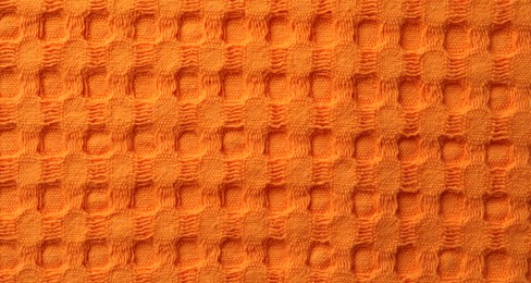 Photo of Texture of orange knitted fabric as background, top view