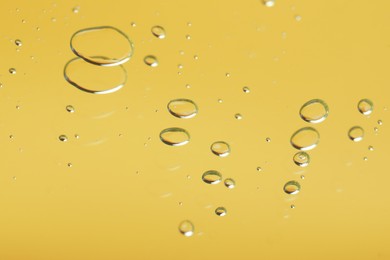 Photo of Many serum drops on mirror, toned in yellow