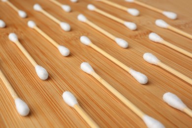 Many clean cotton buds on wooden table, closeup