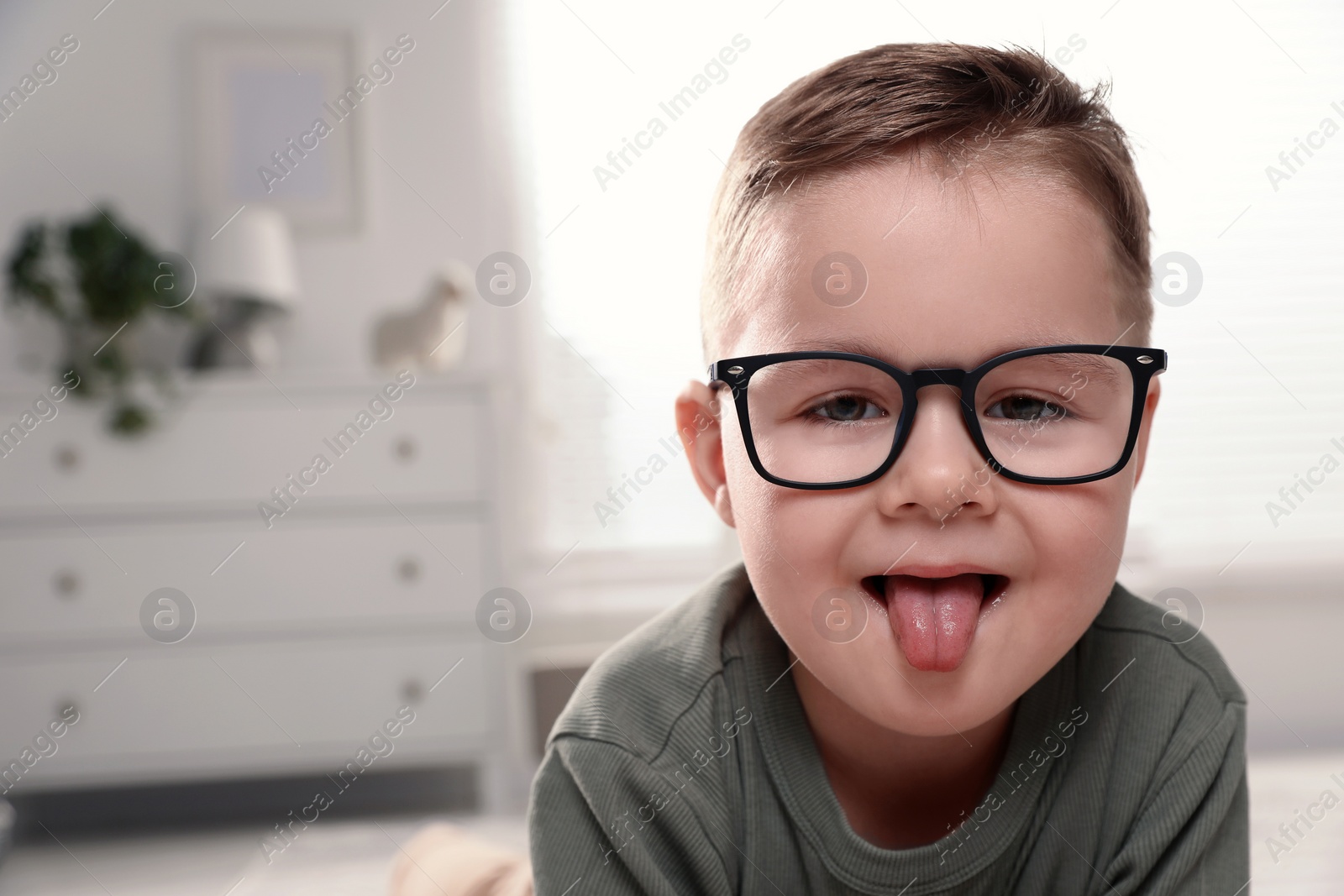 Photo of Cute little boy in glasses at home. Space for text