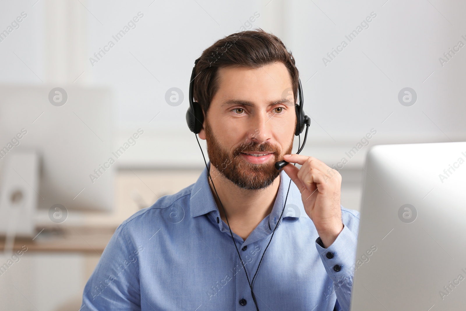 Photo of Hotline operator with headset working in office
