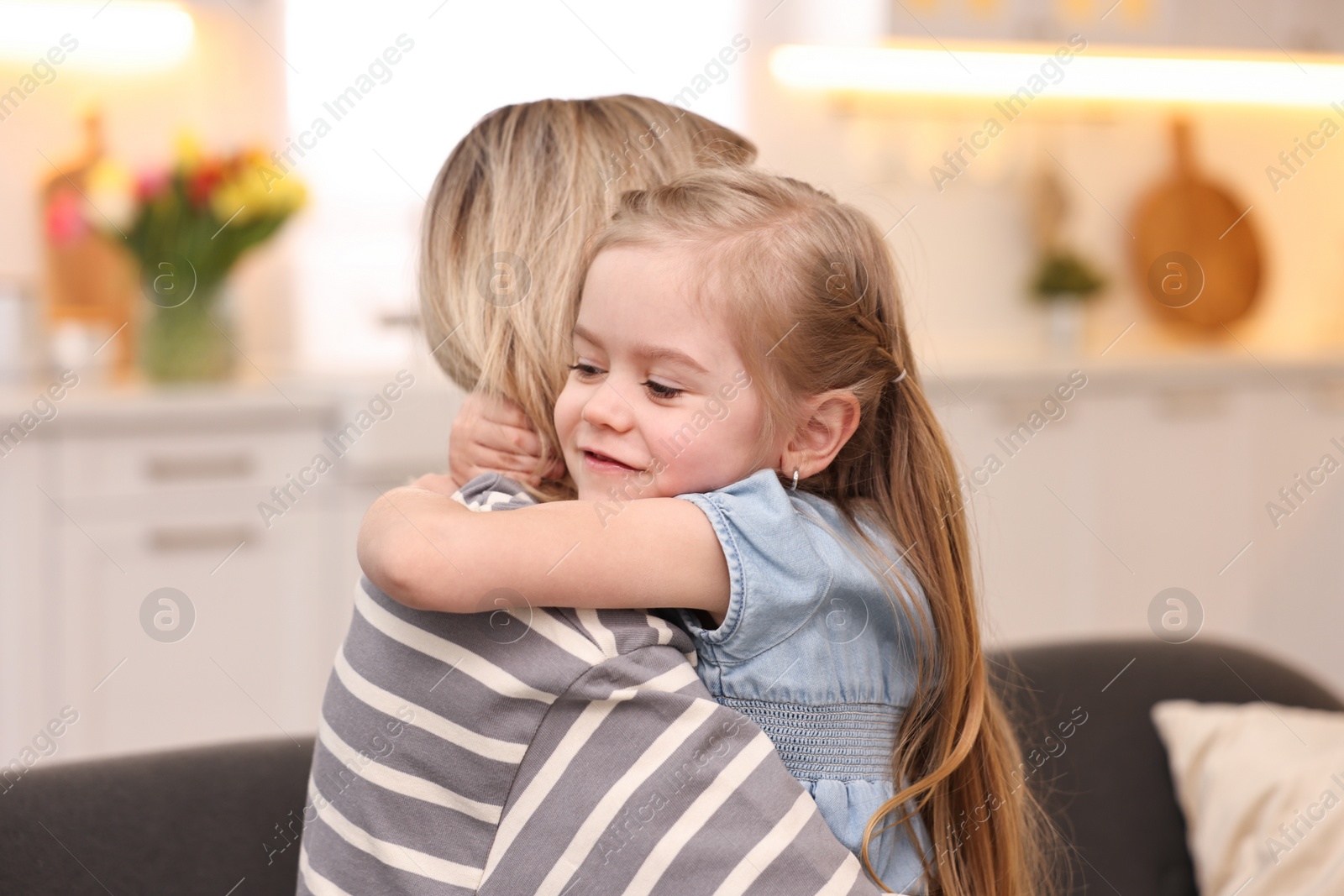 Photo of Cute little girl hugging her mom at home. Happy Mother's Day