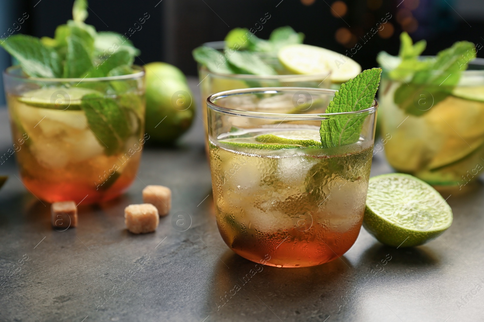 Photo of Glasses with mint julep cocktail on grey table