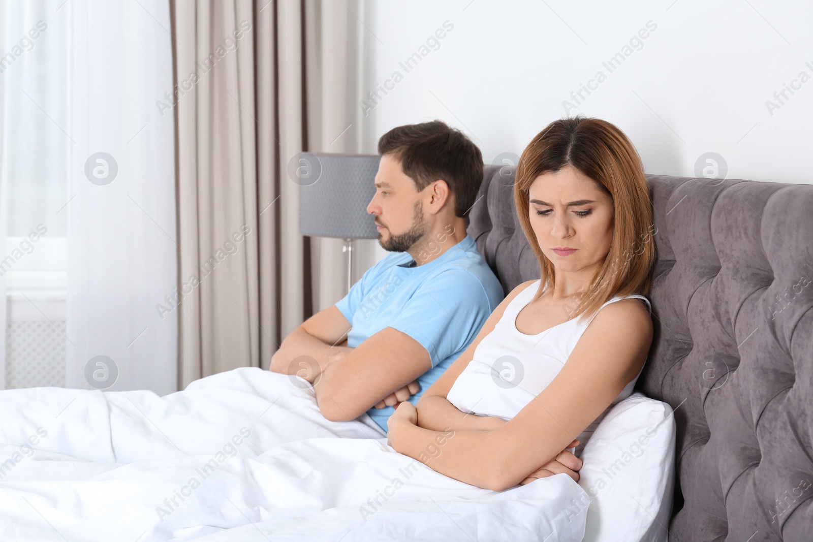 Photo of Couple with relationship problems ignoring each other in bedroom