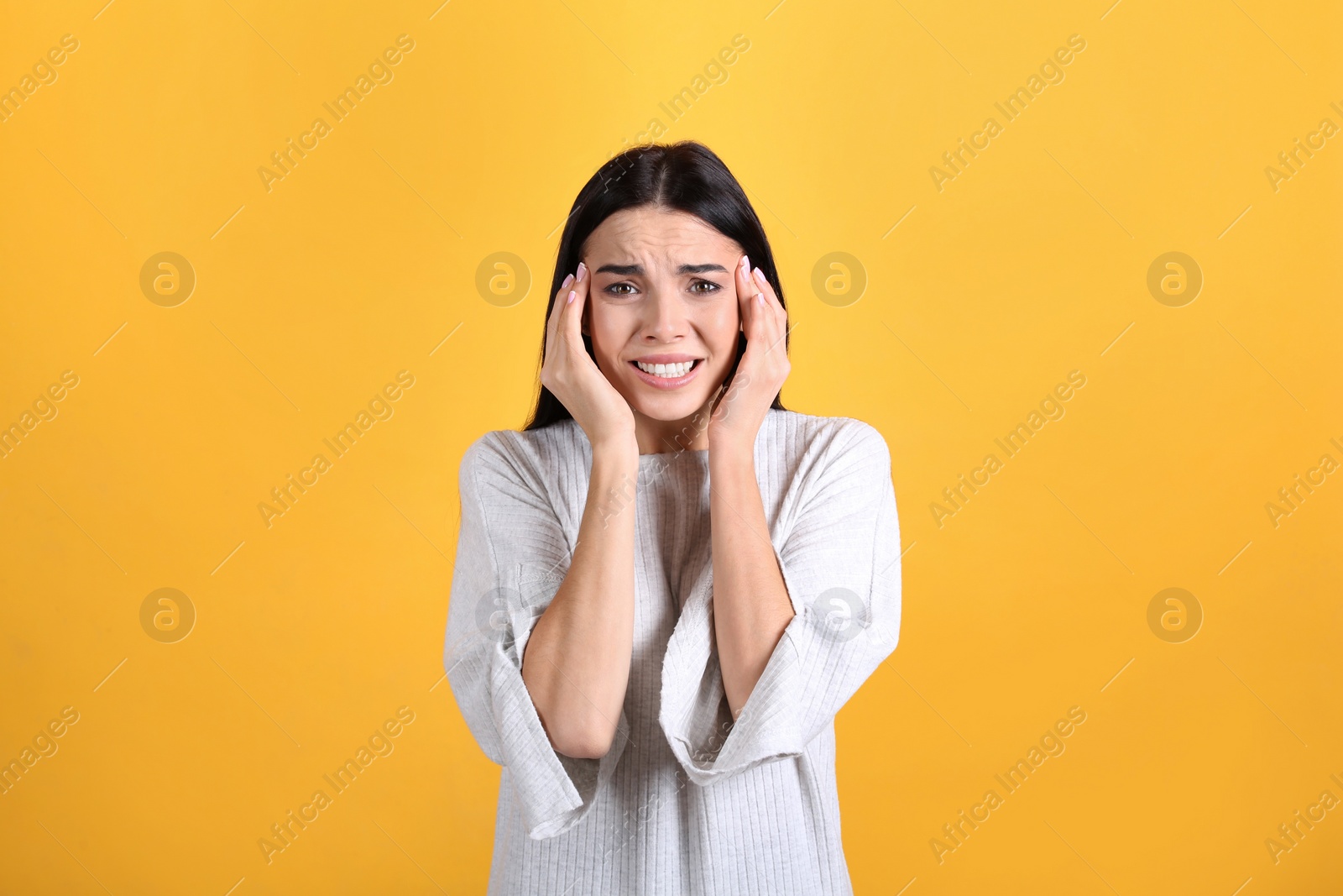 Photo of Portrait of stressed young woman on yellow background