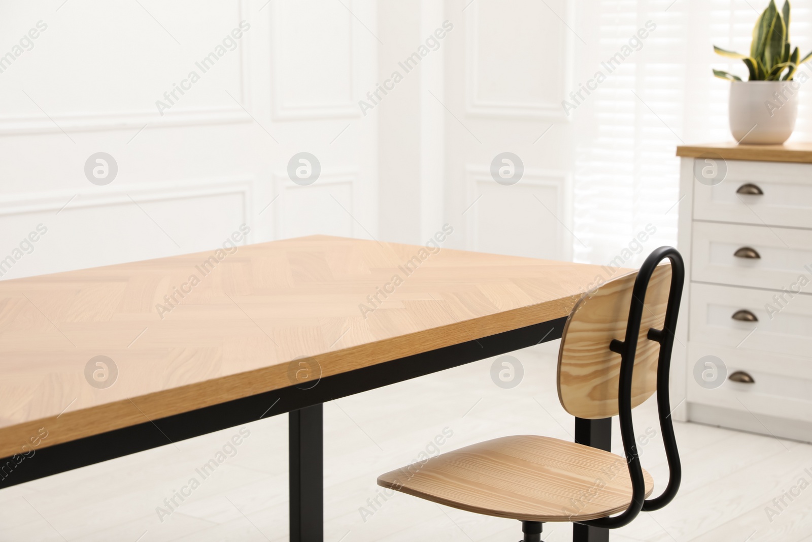 Photo of Wooden table with office chair in room