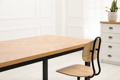 Photo of Wooden table with office chair in room