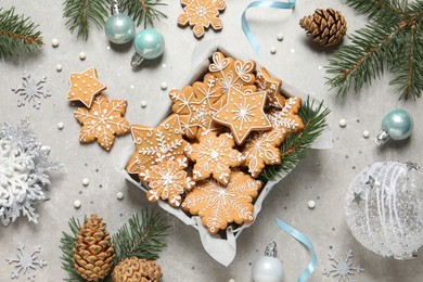 Photo of Tasty Christmas cookies and festive decor on light grey table, flat lay