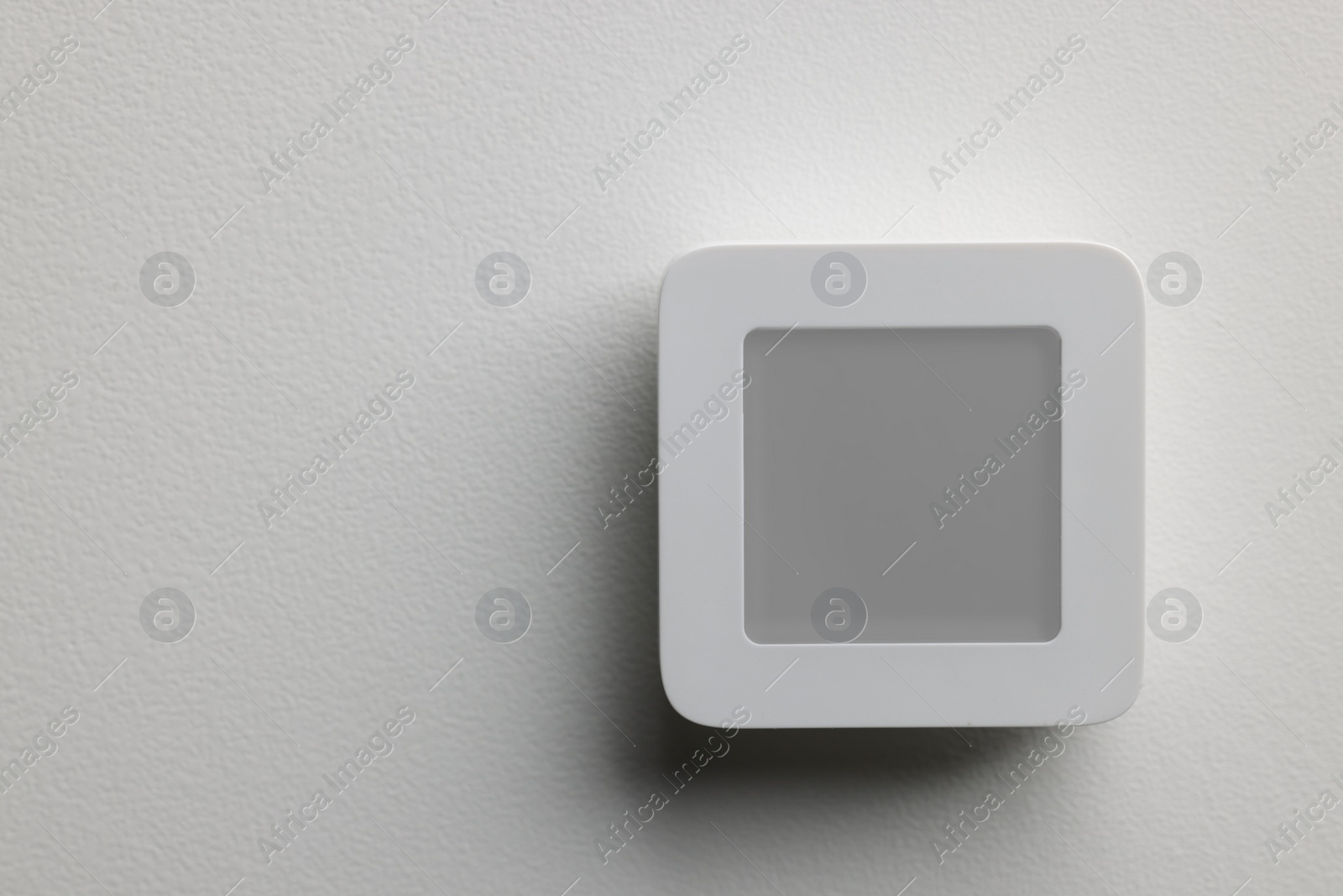 Photo of One thermostat on white wall, space for text. Smart home system