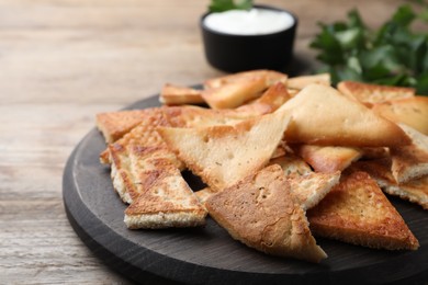 Photo of Delicious pita chips on wooden table, closeup