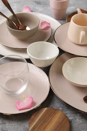 Photo of Stylish table setting. Dishes, cutlery, glass and petals