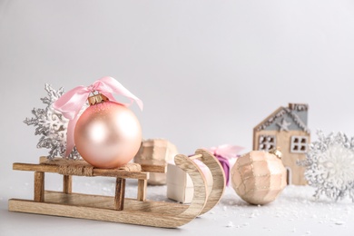 Photo of Beautiful Christmas composition with miniature sleigh on light background