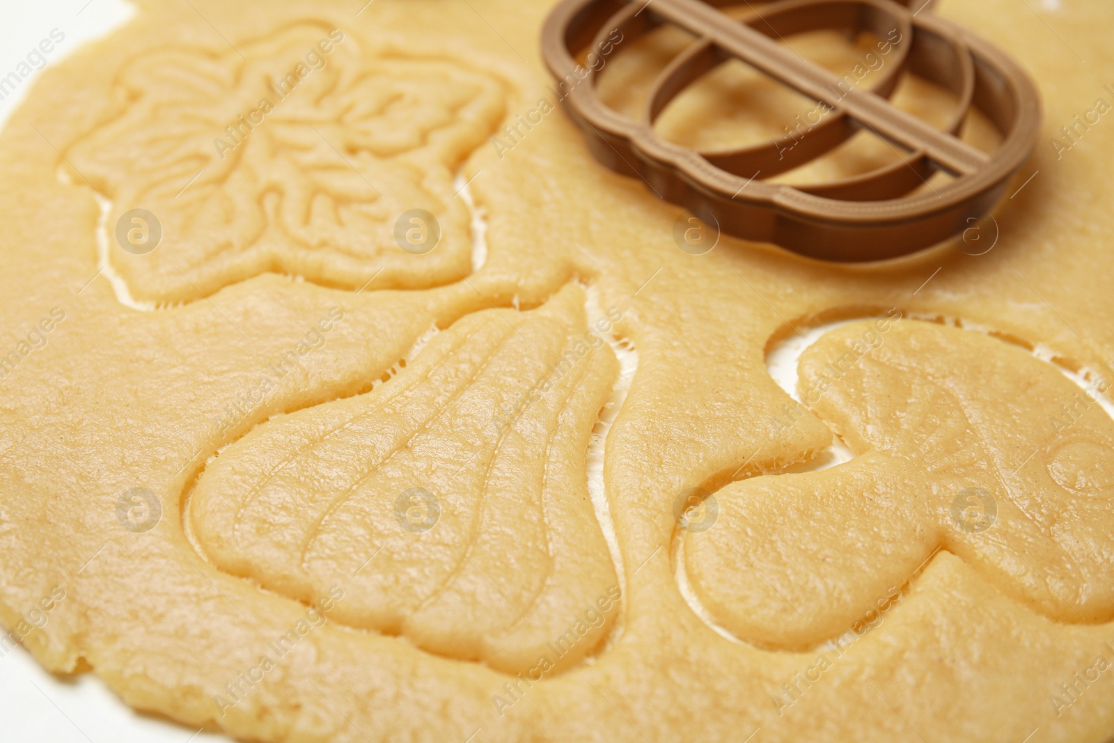 Photo of Cookie cutter and dough on white table, closeup