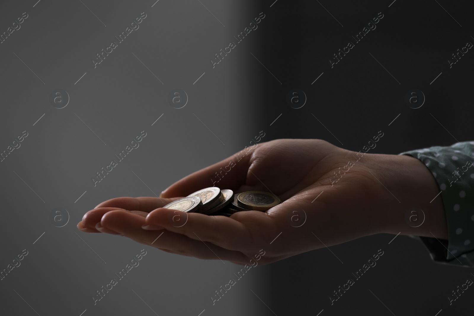 Photo of Woman holding coins on blurred background, closeup. Money saving