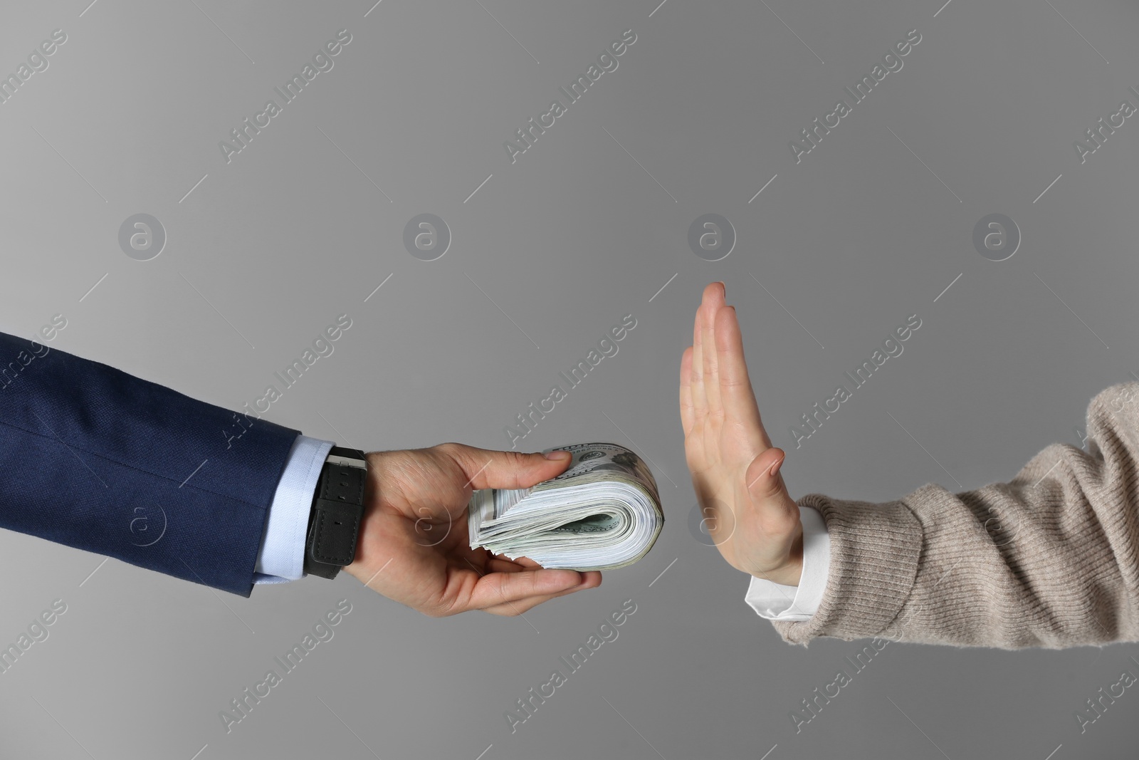 Photo of Woman refusing to take bribe on grey background, closeup of hands