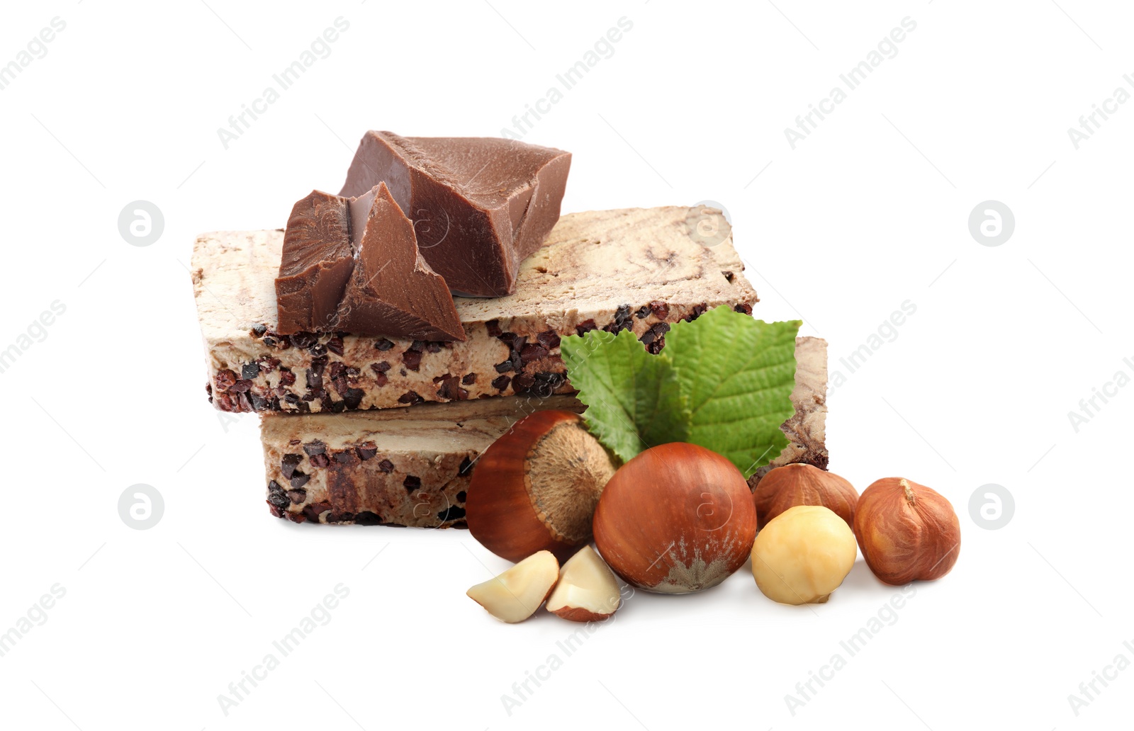 Image of Tasty halva, pieces of chocolate, hazelnuts and green leaves isolated on white