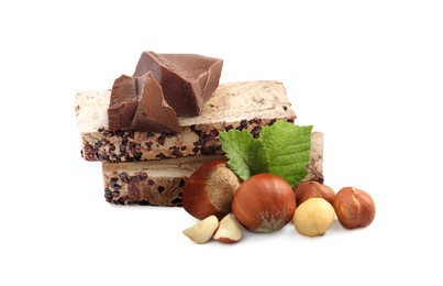 Image of Tasty halva, pieces of chocolate, hazelnuts and green leaves isolated on white