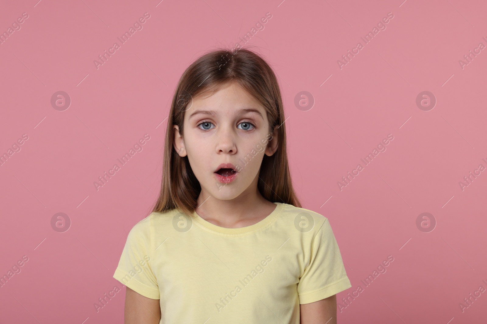 Photo of Portrait of surprised girl on pink background