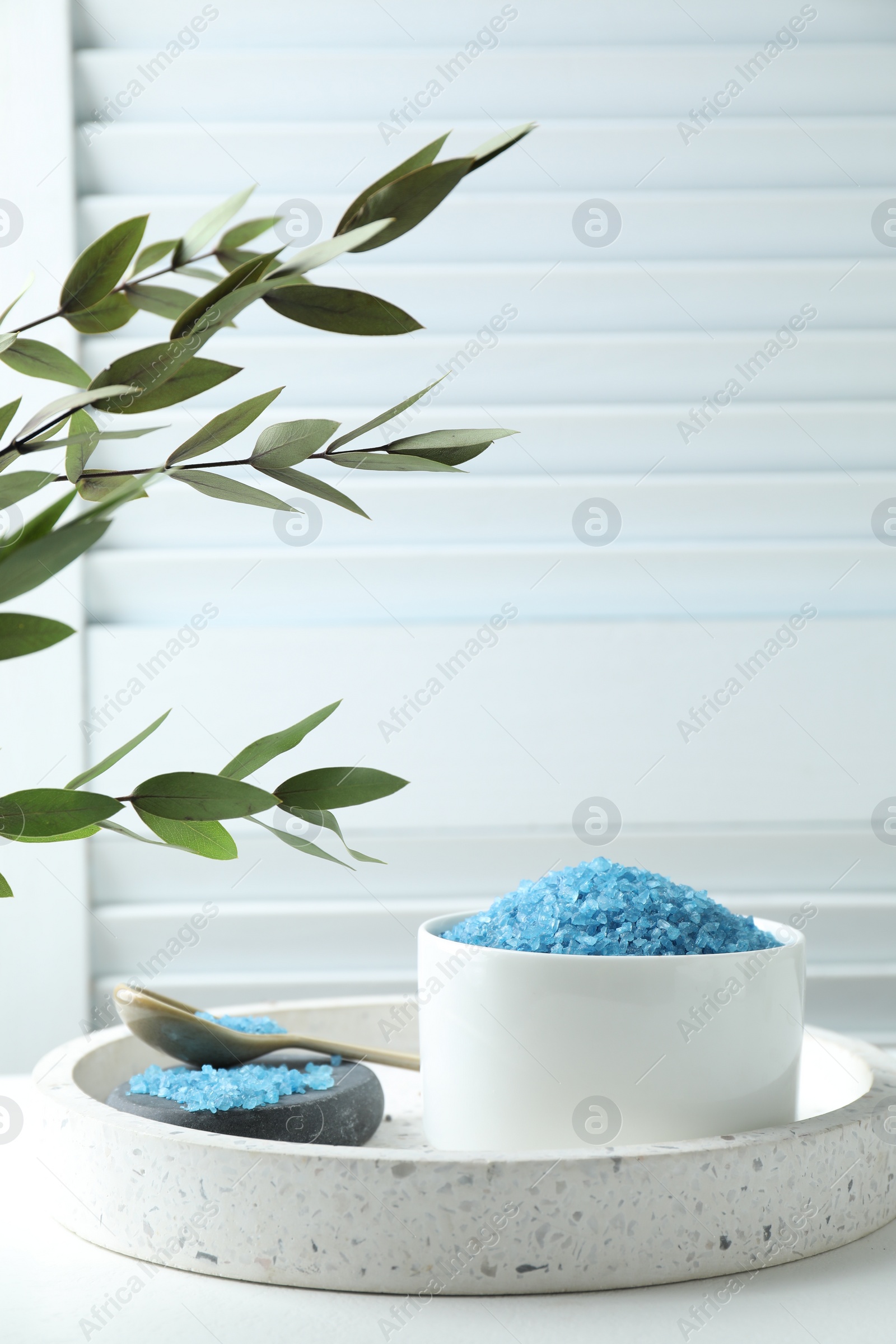 Photo of Blue sea salt on white table indoors, space for text