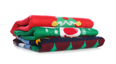 Stack of warm Christmas sweaters isolated on white
