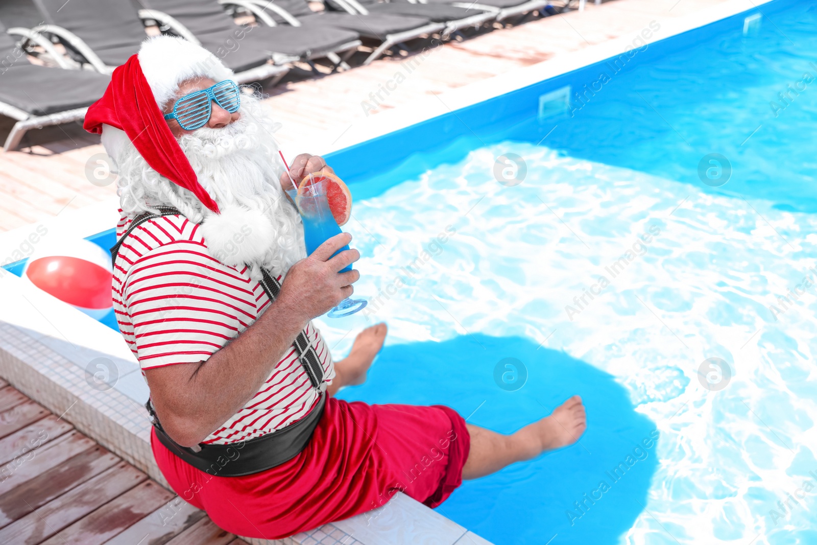 Photo of Authentic Santa Claus with cocktail near pool at resort