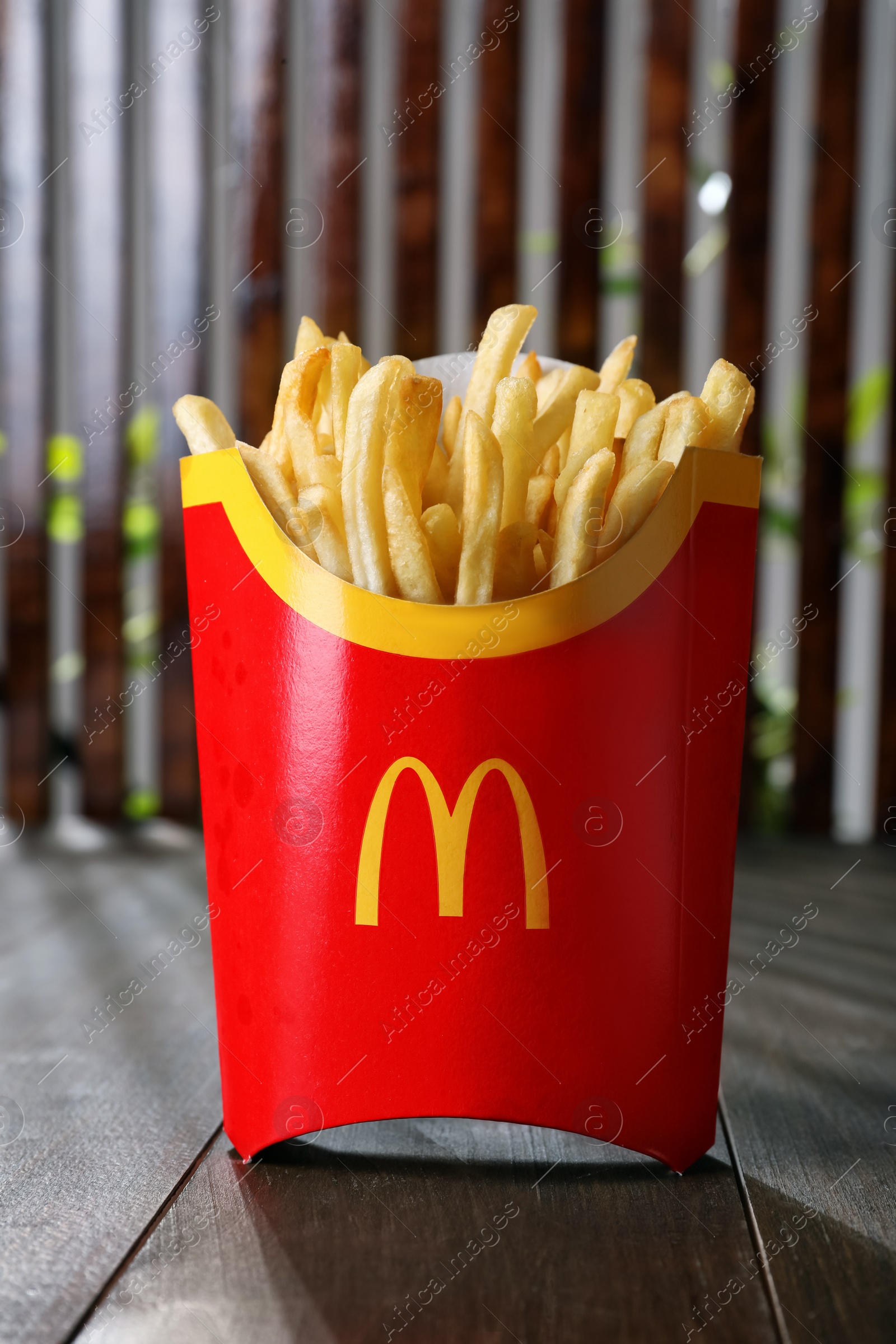 Photo of MYKOLAIV, UKRAINE - AUGUST 12, 2021: Big portion of McDonald's French fries on wooden table