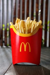 Photo of MYKOLAIV, UKRAINE - AUGUST 12, 2021: Big portion of McDonald's French fries on wooden table