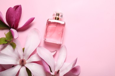 Photo of Beautiful magnolia flowers and bottle of perfume on pink background, flat lay. Space for text