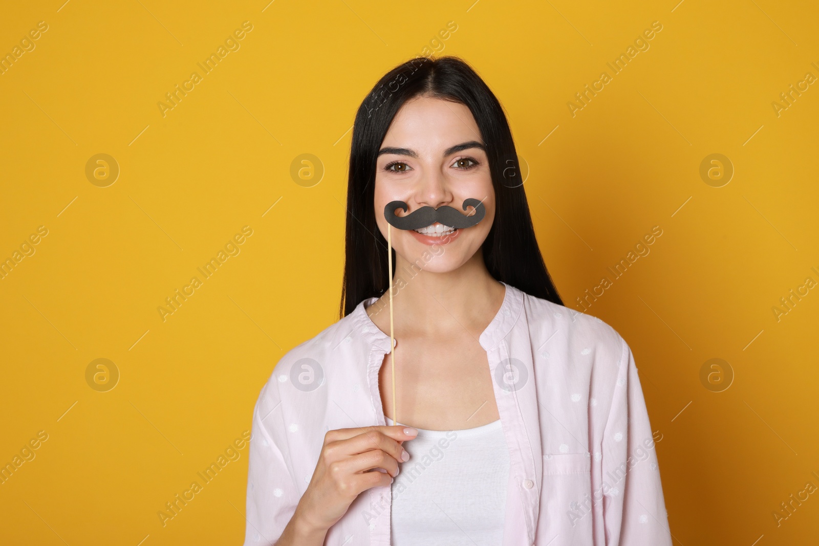 Photo of Pretty woman with fake mustache on yellow background