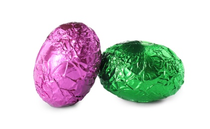 Chocolate eggs wrapped in colorful foil on white background