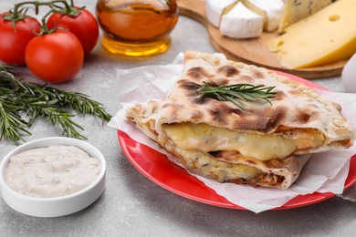 Tasty pizza calzones with cheese, rosemary and different products on light grey table