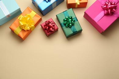 Many colorful gift boxes on beige background, flat lay. Space for text